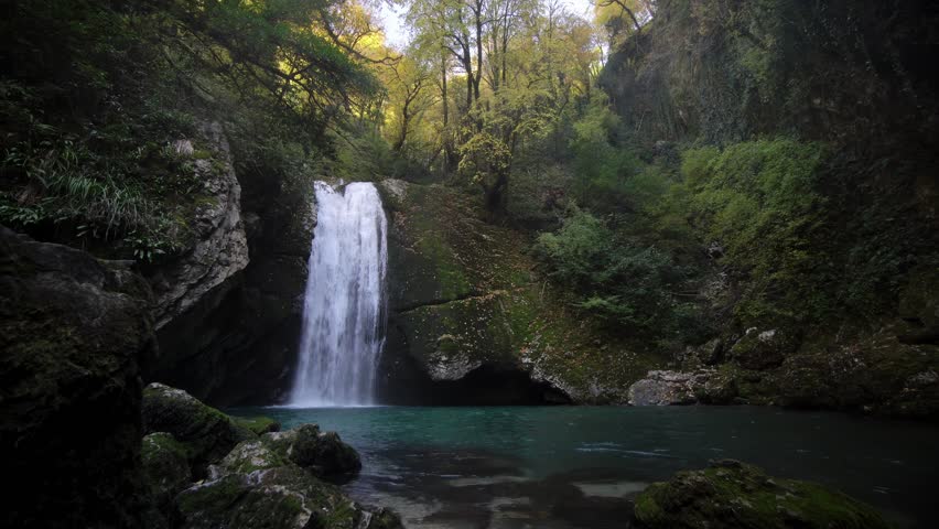 Peaceful Stream Flows Into Bright Pond Setting, Serene Environment with Gentle Cascading Water and Green Scenery, Tranquil Nature Retreat Featuring Soft Waterfalls and Restful Green Water Bodies