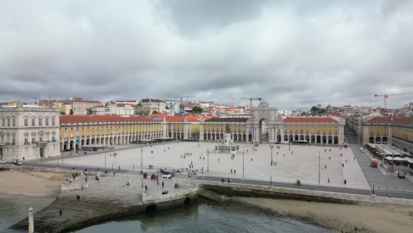 Drone view highlighting classic Lisbon architecture with white and red rooftops and warm sunlight. Perfect for destination videos and city visuals.