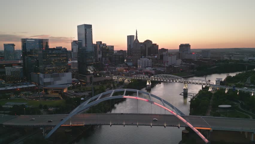 Nashville, Tennessee, USA skyline over the Cumberland River at golden hour.

