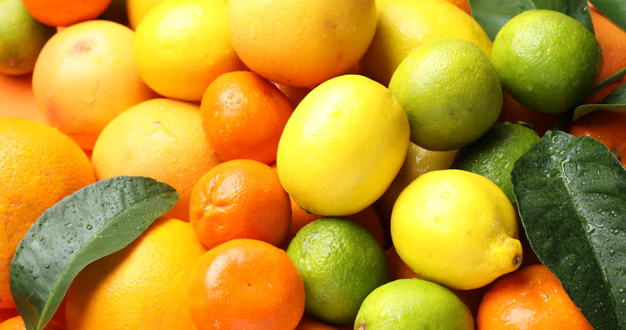 Woman taking different ripe citrus fruits from pile, top view
