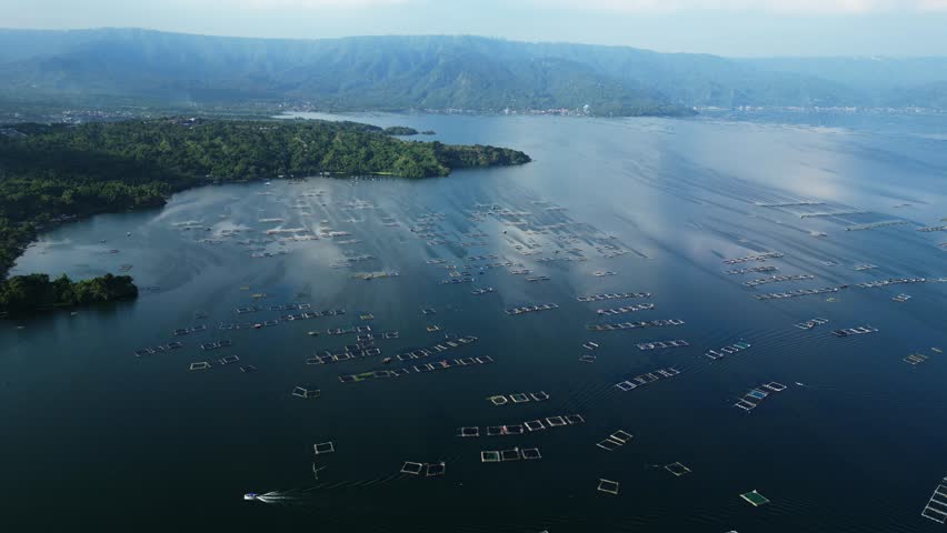 Slow forward shot at Agoncillo Baywalk Road featuring mountain ridges, and square ocean fishponds with tiny boats in one scenic frame Agoncillo Laurel Batangas Philippines