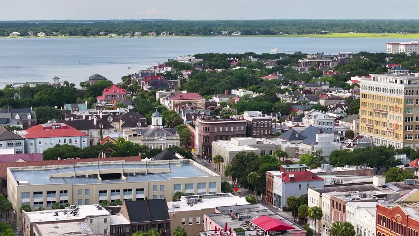 Aerial view of downtown Charleston, South Carolina skyline with surrounding neighborhood homes and cityscape buildings in lowcountry landscape in morning sunrise - 4K Drone