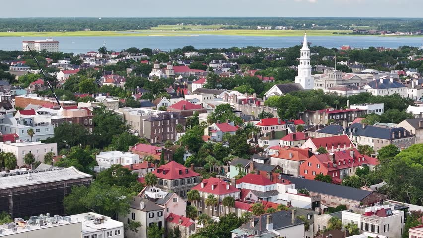 Panoramic aerial view of downtown Charleston, South Carolina skyline with historic churches, surrounding neighborhoods, and cityscape buildings in lowcountry landscape in morning sunrise - 4K Drone