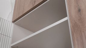 Close up of hands placing spirit level on cabinet shelf inside kitchen cabinet. Using bubble level to verify level during furniture assembly - Powered by Shutterstock - Get 15% off with code: PIKWIZARD15