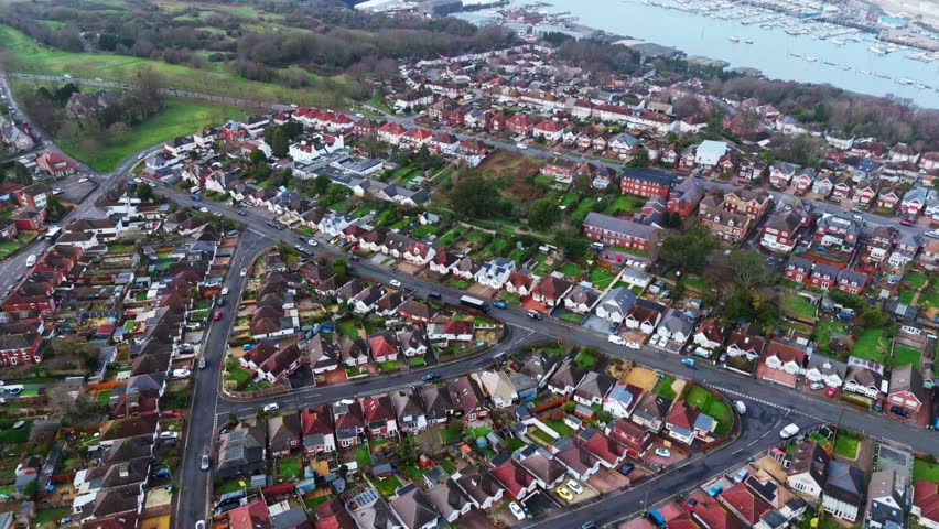 aerial landscape drone shot panning over the Woolston and Itchen suburbs of Southampton, Hampshire. With lots of houses and fields and trees lining the busy roads in the area on a winters day