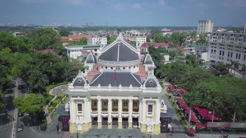 Aerial shot slowly revealing the hanoi opera house and the surrounding city skyline in vietnam