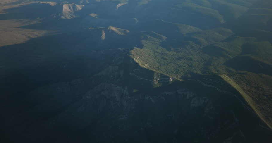 Daytime summer aerial footage filmed from an airplane flying over mountainous terrain near Albuquerque, New Mexico during the Southwest monsoon season. The video features rugged desert mountains beneath dramatic monsoon clouds and changing atmospheric conditions, highlighting seasonal weather patterns in the American Southwest. Ideal for weather, climate, environment, travel, and scenic landscape stock footage.