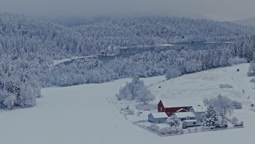 Countryside House In Deep Snow Landscape Near Forest Mountain Lake. Aerial Shot