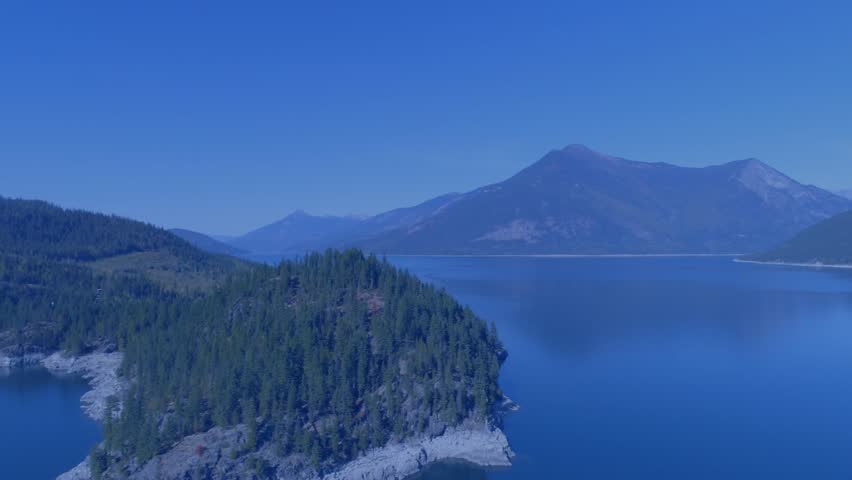 Initial pale star appearing above lake other stars fading shifting glowing forming twelve star ring. Circle, golden, animated, aerial, drone, mountains, peninsula