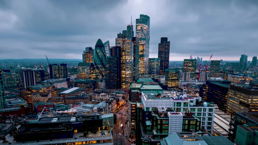 Aerial hyper lapse view of the City of London skyline during dusk with fast moving clouds