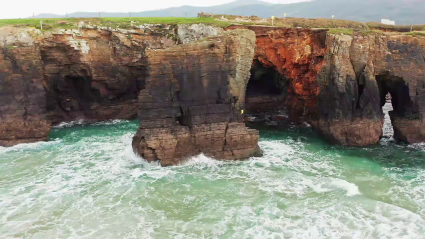 Dynamic ocean waves crash against rugged cliffs, showcasing the natural beauty of Guam