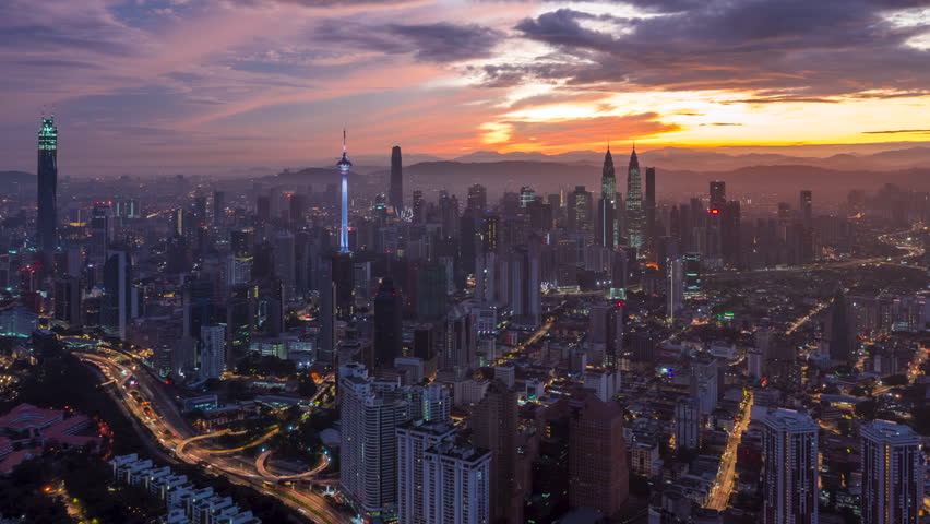 Colorful sunrise time lapse view of overlooking urban forest and roads with KL skyline in background in Asia. Kuala Lumpur, Malaysia. 