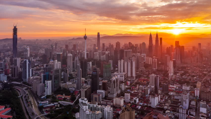 Colorful sunrise time lapse view of overlooking urban forest and roads with KL skyline in background in Asia. Kuala Lumpur, Malaysia. 