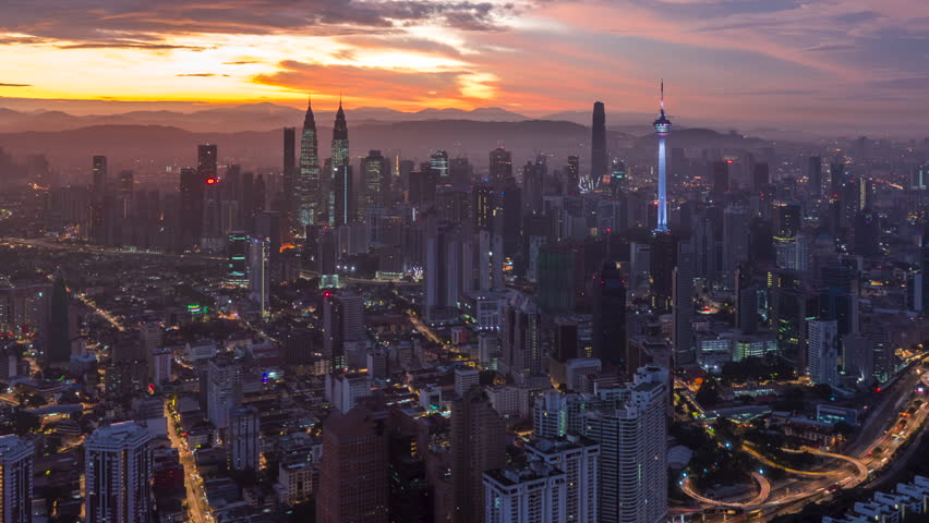 Colorful sunrise time lapse view of overlooking urban forest and roads with KL skyline in background in Asia. Kuala Lumpur, Malaysia. 