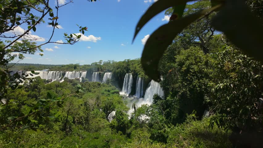 Dolly in toward Alvar Nunez waterfalls across green rainforest gorge, Iguazu Falls Argentina.