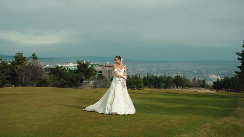 Joyful young bride enjoying the outdoor celebration on a meadow at sunset