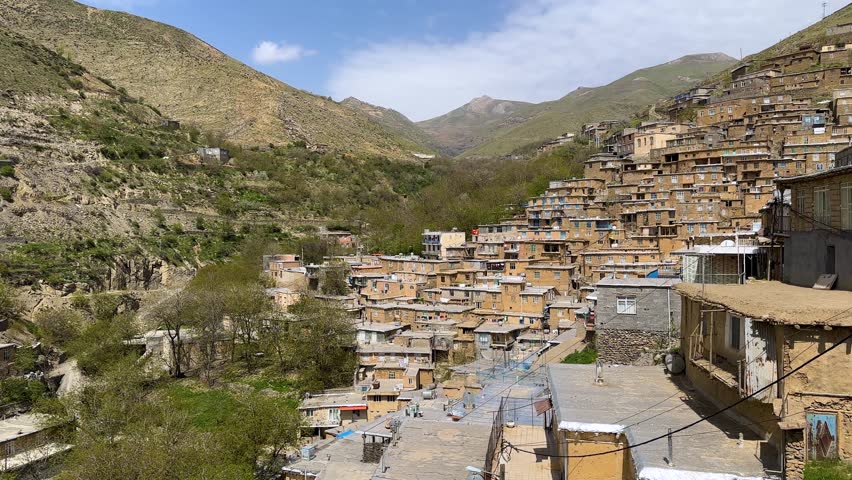 stepped brick village Kurdistan rugged slope Zagros mountain cascade stone traditional architecture local landscape cultural earthen roof rustic red Iran timber brown sunset golden hour green serene