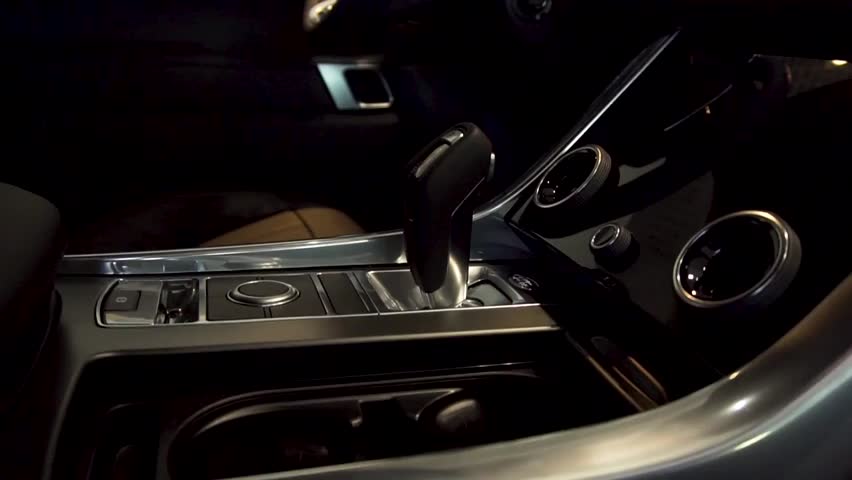 Close-up of a modern luxury car’s automatic gear stick, highlighting interior details, automatic transmission, and automotive design.