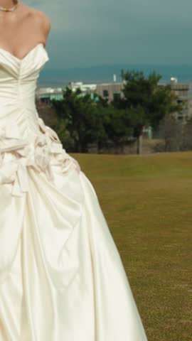Joyful young bride enjoying the outdoor celebration on a meadow at sunset