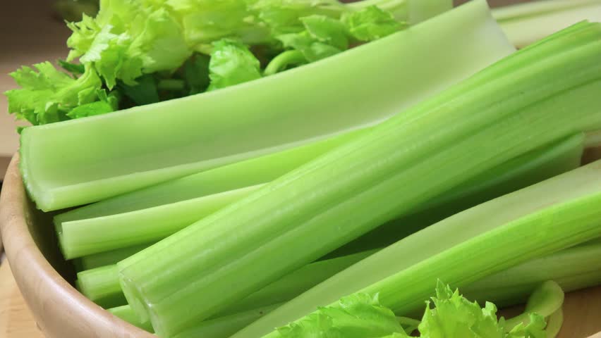 Fresh celery in a wooden bowl.