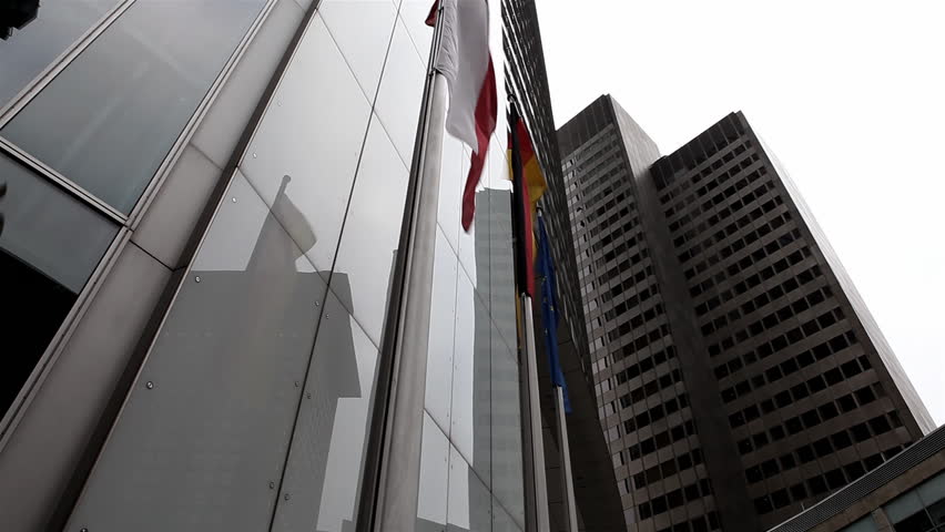 Waving flags infront of skyscrapers in a wide angle / HD1080 / 30fps