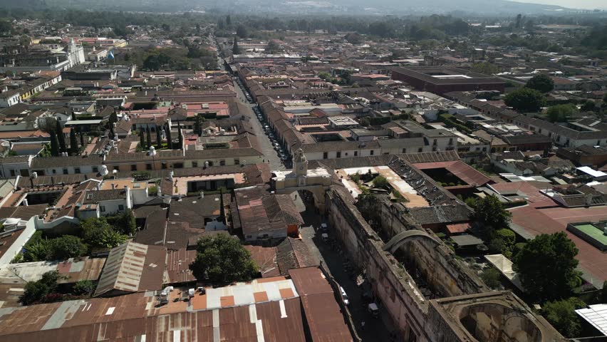 Aerial reveal volcano Volcan Agua from famous Arch Arco de Santa Catalina in Antigua Guatemala