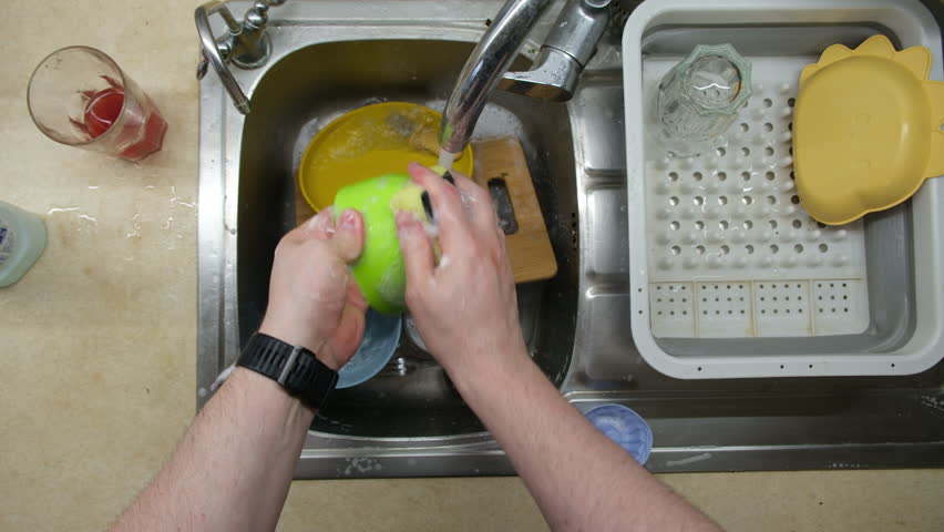 Washing Dishes in Kitchen Sink Overhead