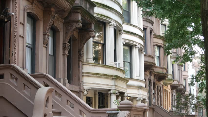 New York City townhouse buildings, brownstone row houses in Manhattan or Brooklyn, United States of America. Classic buildings on residential district street. Real estate property. Rowhouse townhome.
