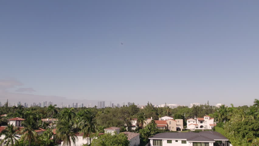 Plane flying over neighborhood in Miami, aerial drone