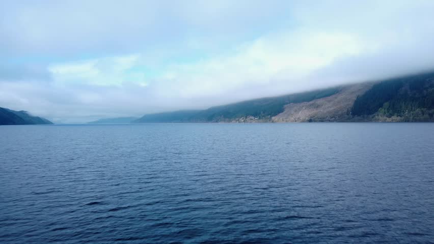 Tracking In Low Drone Shot with slight left Pan of Loch Ness early in the morning.