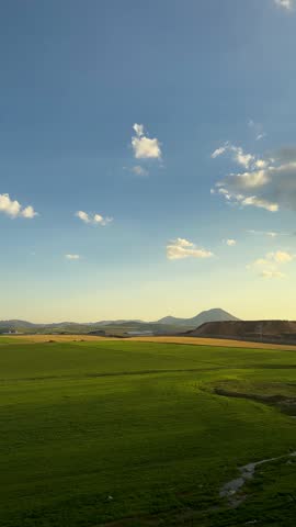 iran road trip blue sky clouds green field Kurdistan nature wonderful landscape travel panoramic agriculture meadow scenic agricultural farm farmland grain harvest industrial silos processing plant