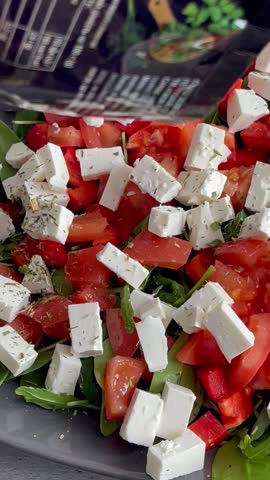 Fresh salad with tomatoes, feta cheese and herbs.