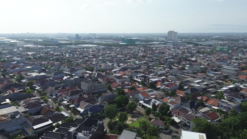 Aerial drone view of Surabaya city suburbs and hazy horizon 4K