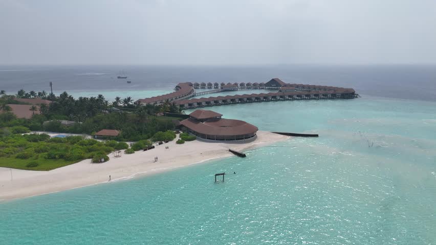 Aerial View of Luxury Overwater Resort Villas in Turquoise Lagoon Maldives 4K