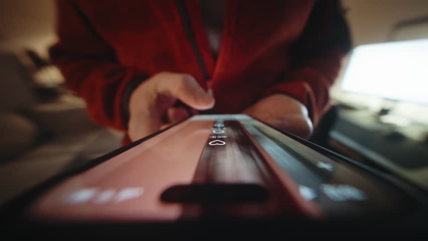 Close-up wide angle male hand holding smartphone, swiping finger. Man scrolling social media feed on phone screen at home. Camera locked extremely close to device, motion background