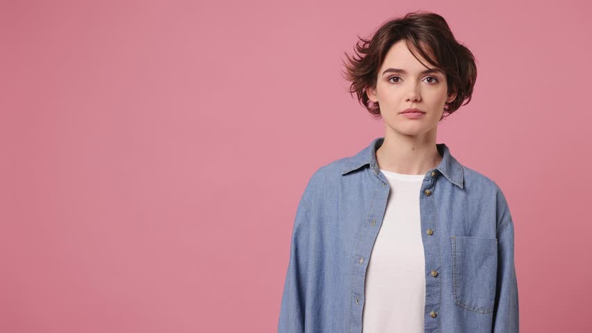 Young woman wears blue shirt white t-shirt casual clothes pointing indicate index finger aside on workspace area copy space mock up isolated on plain pastel light pink background. Lifestyle concept