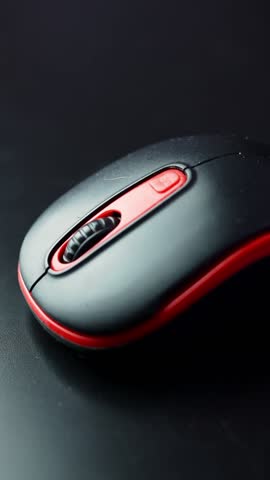 Extreme macro of a black and red computer mouse showing the textured scroll wheel and buttons in soft light—clean tech b-roll for productivity, gaming, and UI themes.