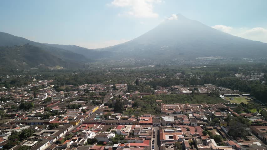 Wide aerial view of historic city Antigua Guatemala with Volcan de Agua in hazy dry season