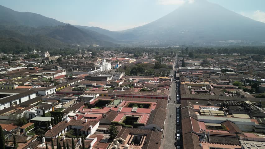 Aerial of downtown Antigua Guatemala Parque Central and Volcan Agua with hazy sky
