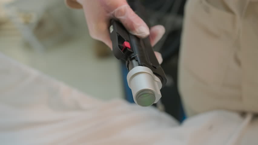 Professional doctor holding a laser hair removal handpiece in a beauty clinic.