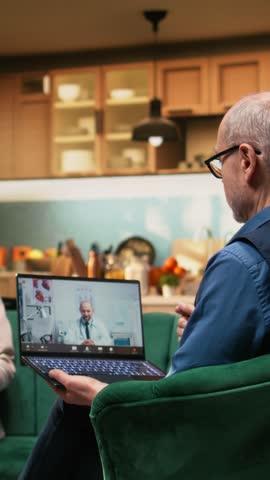 Vertical Video Elderly people participating in virtual telehealth conference with physician from their home. Senior woman holding box of vitamins to ask medic about dosage and daily administration
