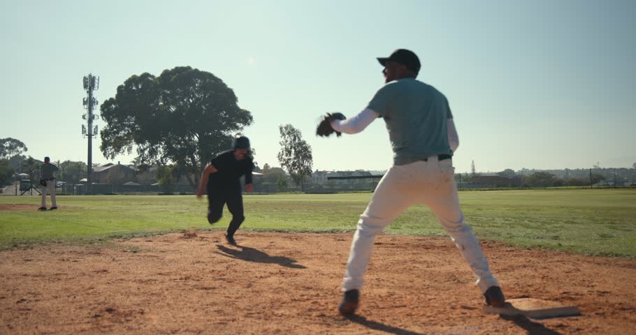 Sprinting toward base bag, runner sliding headfirst under glove to avoid tag at community diamond. Action, sport, athleticism, competition, outdoor, dynamic, momentum