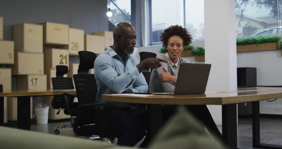Man pointing at laptop starting play icons and alerts layering, woman engaging, reviewing business. Collaboration, colleagues, office, teamwork, discussion, computer, planning