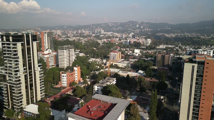 Aerial panning above zona 14 in downtown Guatemala City mountains and skyscrapers