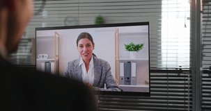 Woman on video call in office meeting. She is talking in an online business chat on a large screen, suited for remote support and interviews. Clear concept of remote business communication. - Powered by Shutterstock - Get 15% off with code: PIKWIZARD15