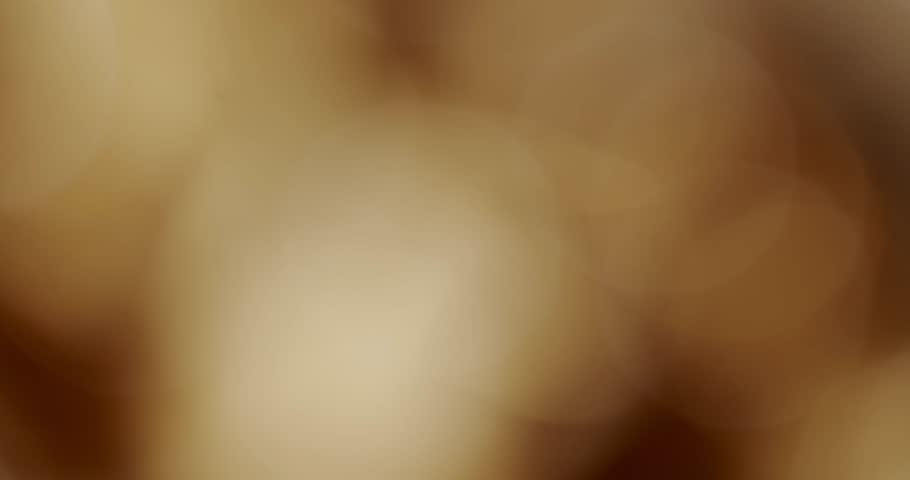 Abstract soft-focus background with beautiful glittering golden bokeh lights creating a warm and elegant atmosphere, perfect for overlays, holidays, and celebrations