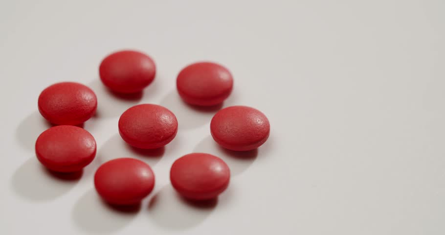 Medical red tablets isolated on a white background disappearing sequentially one after another, representing a course of treatment, daily dosage, or the process of healing and recovery