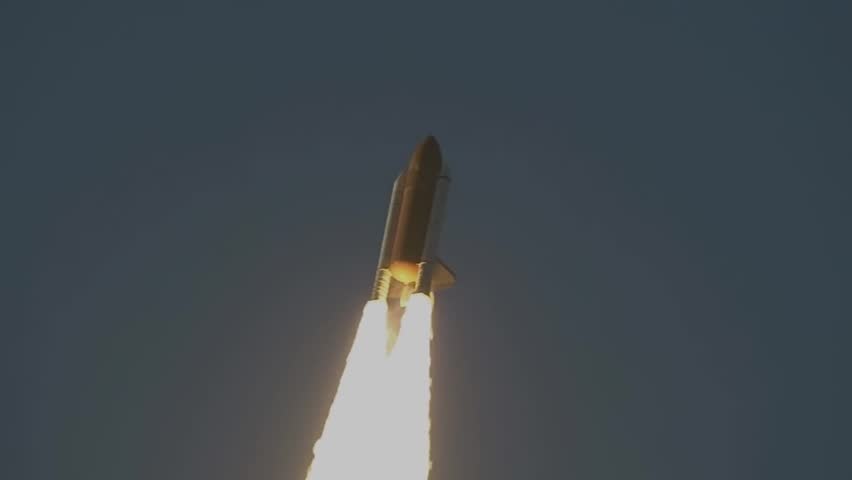 Space Shuttle moving into the sky with smoke trails.