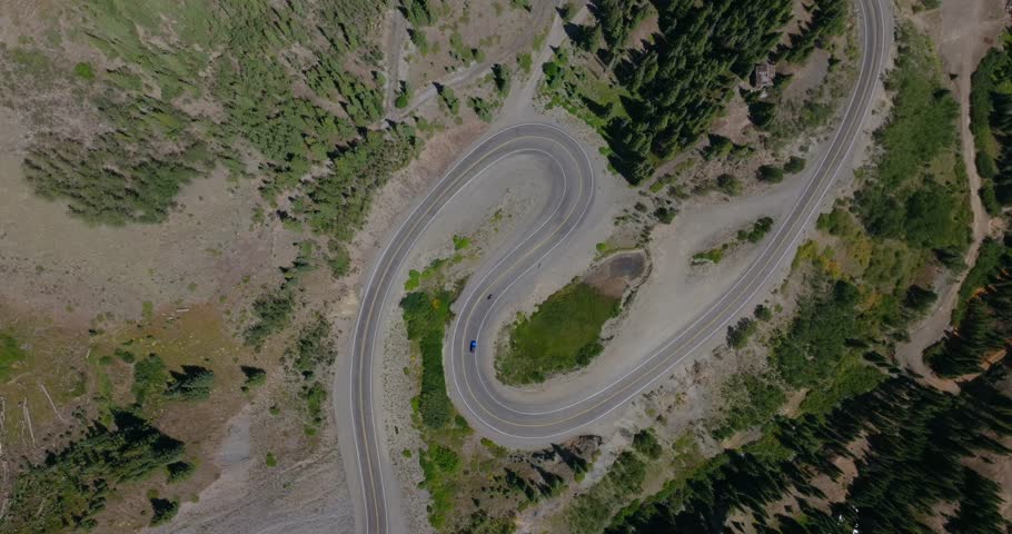 Dramatic aerial of steep mountain switchbacks cutting by rugged Colorado terrain, Million Dollay Highway Colorado USA