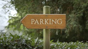 Rustic Wooden Sign - PARKING Engraved Vertically In White Capital Letters. Close-up Shot - Powered by Shutterstock - Get 15% off with code: PIKWIZARD15